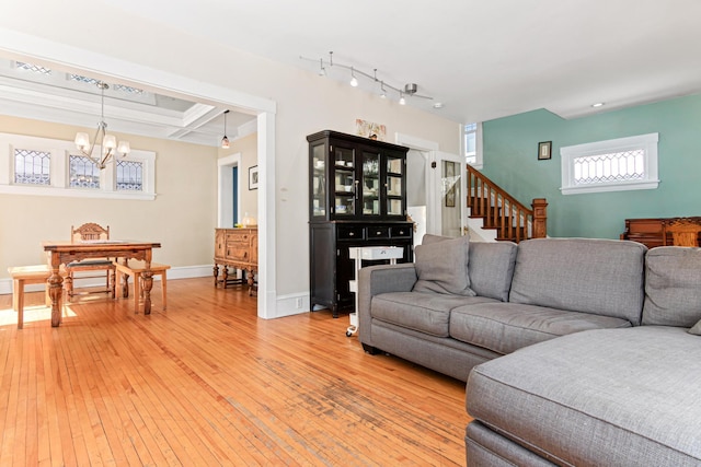 living room with baseboards, stairs, light wood-type flooring, a notable chandelier, and coffered ceiling