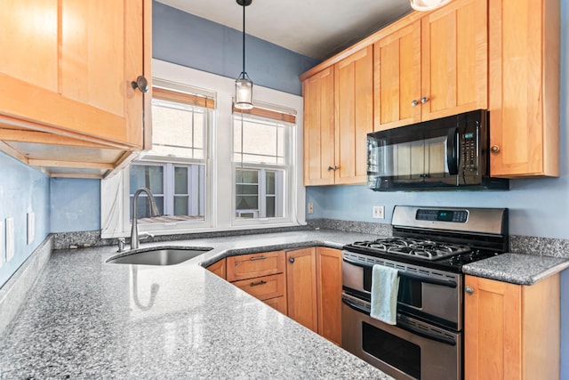 kitchen featuring black microwave, light brown cabinetry, double oven range, pendant lighting, and a sink