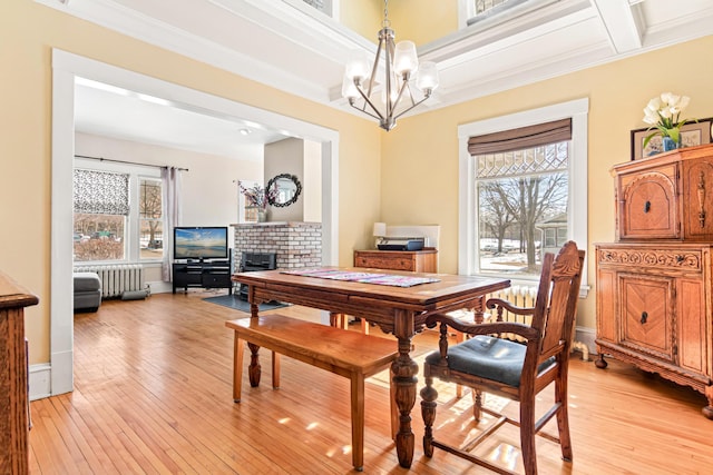 dining room featuring a wealth of natural light, light wood-style flooring, radiator, and coffered ceiling