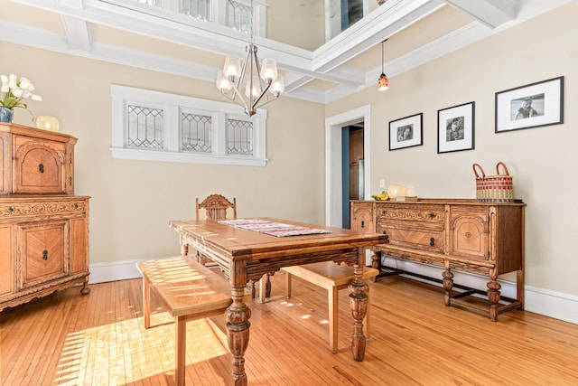 dining area with light wood finished floors, baseboards, coffered ceiling, and a chandelier