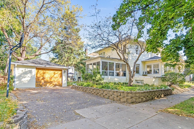 view of front of house featuring a garage, an outbuilding, and a sunroom