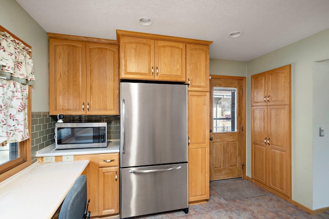 kitchen featuring tasteful backsplash, baseboards, light countertops, recessed lighting, and stainless steel appliances