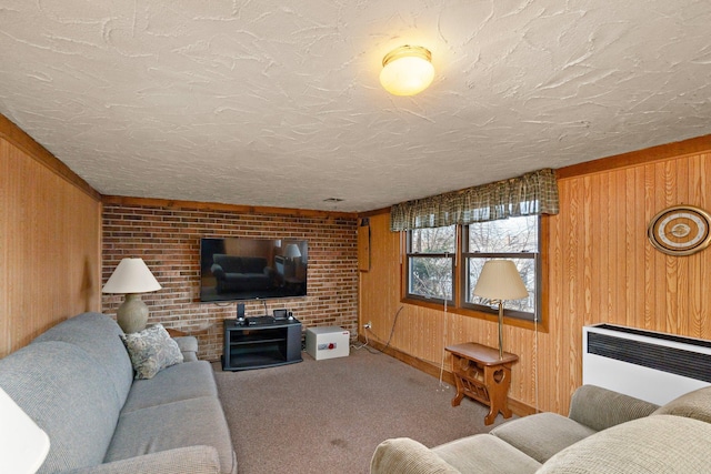 carpeted living area with wooden walls, radiator, and a textured ceiling