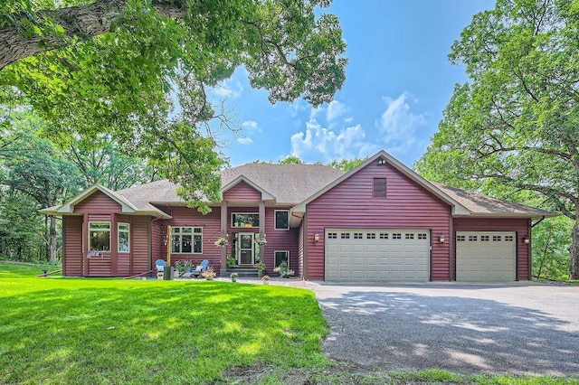 ranch-style home featuring a garage, driveway, roof with shingles, and a front yard