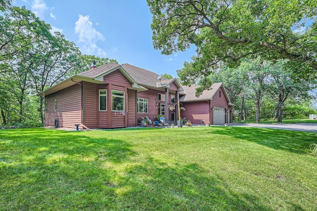 view of front facade featuring aphalt driveway, an attached garage, and a front lawn