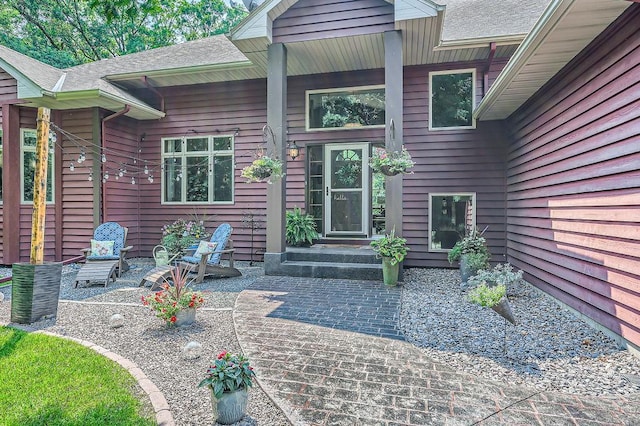 entrance to property featuring a shingled roof