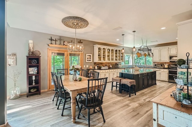 dining space with visible vents, light wood-style flooring, recessed lighting, an inviting chandelier, and baseboards