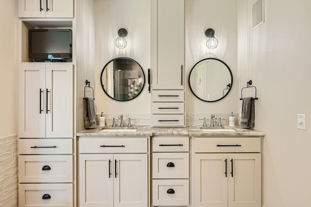 full bathroom with double vanity and a sink