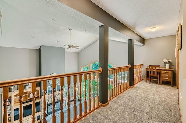 hall with baseboards, carpet, and a textured ceiling