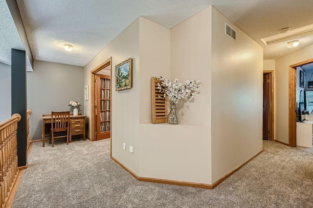 corridor with carpet flooring, baseboards, visible vents, and a textured ceiling