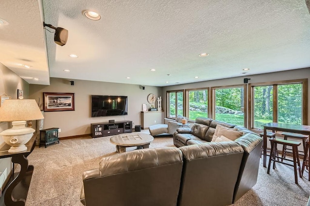 carpeted living area with recessed lighting, a textured ceiling, and baseboards