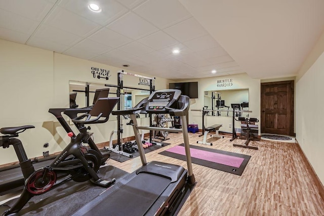 workout room with recessed lighting, a drop ceiling, baseboards, and wood finished floors