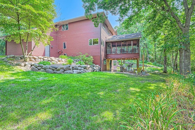 rear view of house with a lawn and a sunroom