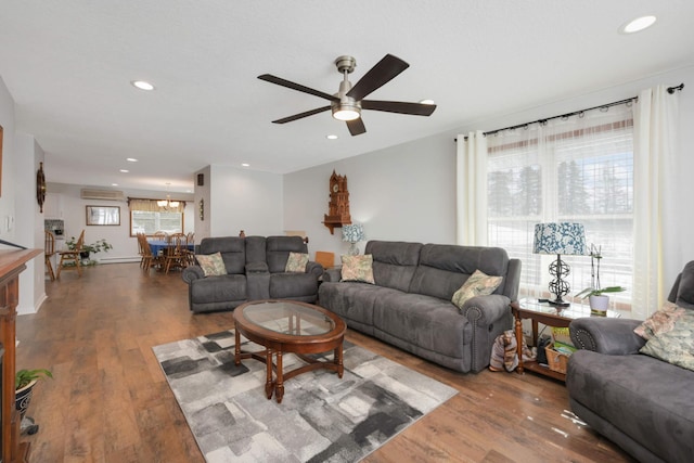 living area featuring recessed lighting, a healthy amount of sunlight, ceiling fan with notable chandelier, and wood finished floors