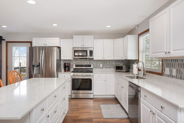 kitchen featuring a sink, appliances with stainless steel finishes, dark wood finished floors, and a healthy amount of sunlight