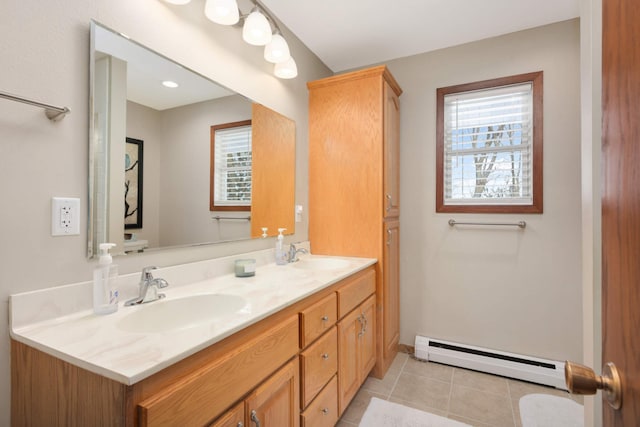 full bath with tile patterned flooring, double vanity, baseboard heating, and a sink