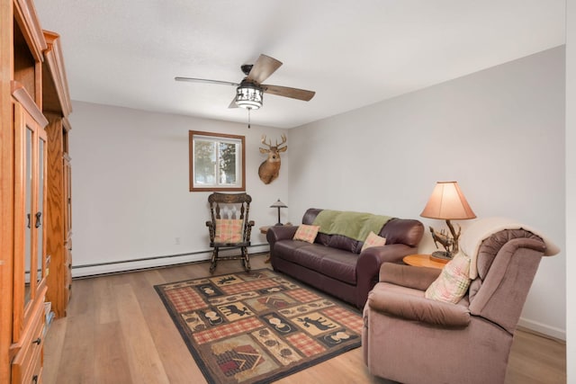 living room with a baseboard heating unit, wood finished floors, and a ceiling fan