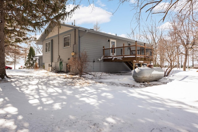 snow covered property featuring a deck