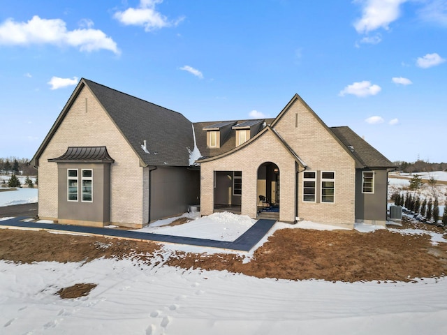 view of front of house with brick siding and central AC