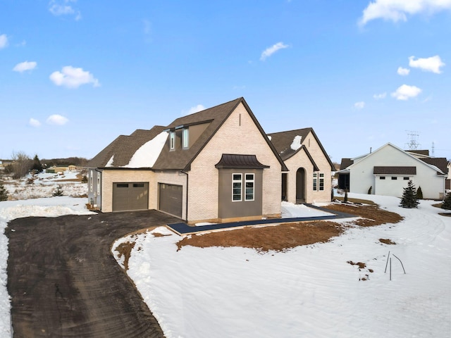 view of front facade with brick siding, driveway, and an attached garage