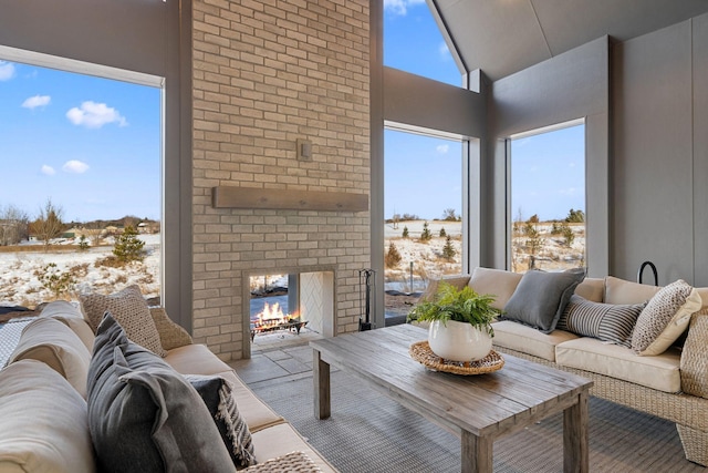 living area featuring a high ceiling and an outdoor brick fireplace