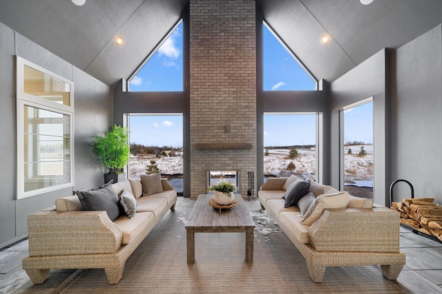 living room with high vaulted ceiling and a fireplace