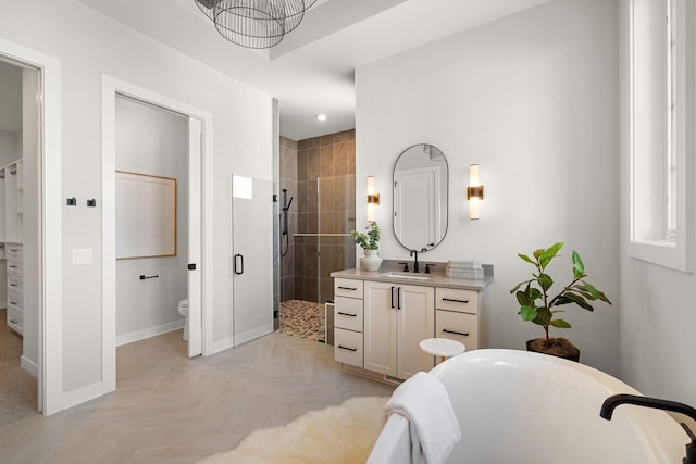 bathroom featuring a freestanding tub, toilet, a shower stall, baseboards, and vanity