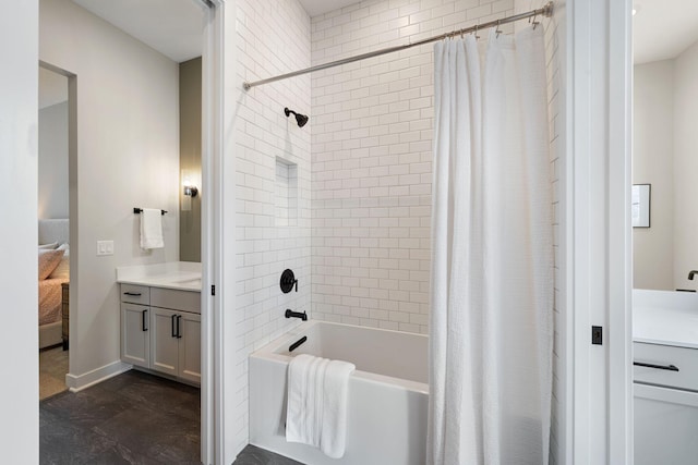 ensuite bathroom with ensuite bathroom, vanity, shower / bath combo with shower curtain, and baseboards