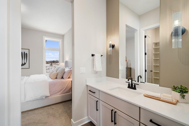 ensuite bathroom featuring baseboards, vanity, a spacious closet, and ensuite bathroom