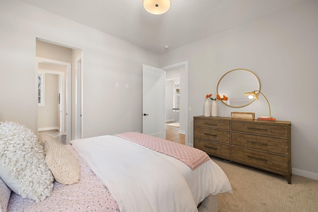 bedroom featuring light colored carpet and baseboards