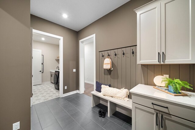 mudroom with dark floors and baseboards