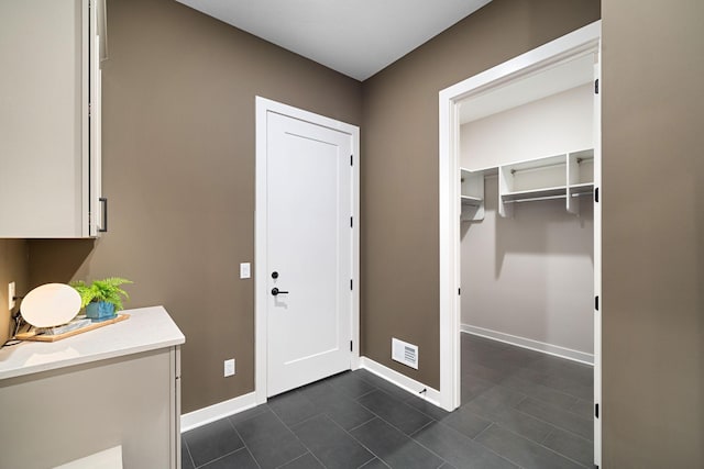 laundry area with baseboards and visible vents