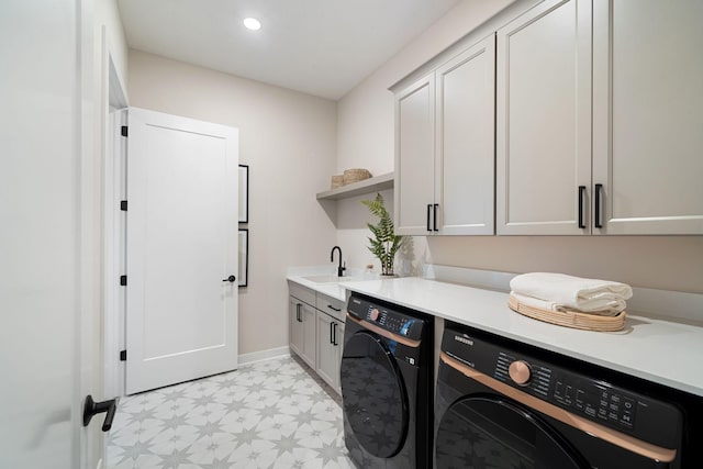 washroom with washer and dryer, a sink, recessed lighting, cabinet space, and light floors