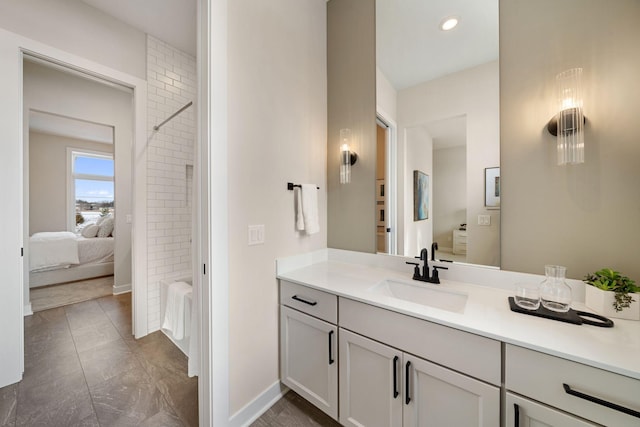 ensuite bathroom with recessed lighting, connected bathroom, baseboards, and vanity