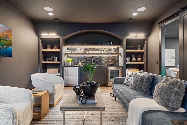 living area featuring beverage cooler, recessed lighting, a textured ceiling, and a barn door