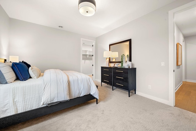 bedroom featuring baseboards and light carpet