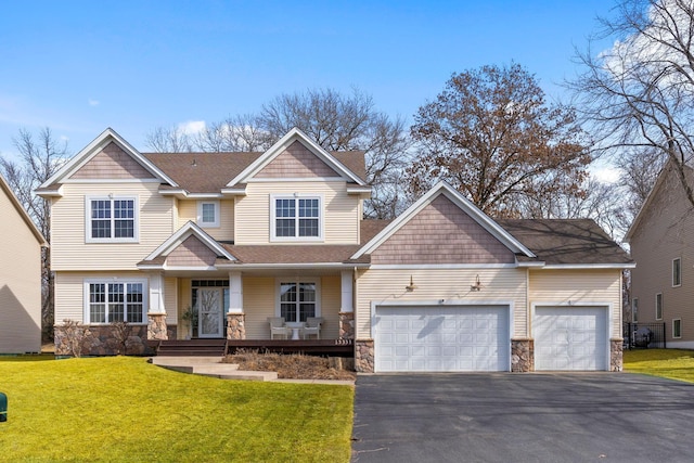 craftsman-style home with a front lawn, a garage, stone siding, and aphalt driveway