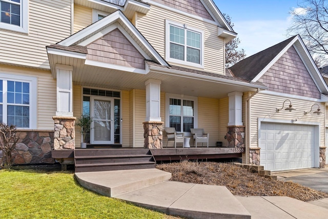 view of front of house with stone siding, a porch, and an attached garage