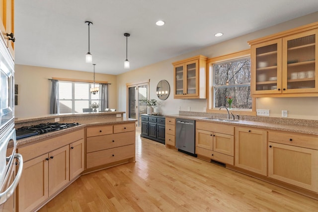 kitchen featuring light brown cabinets, black gas cooktop, light wood-type flooring, stainless steel dishwasher, and a sink