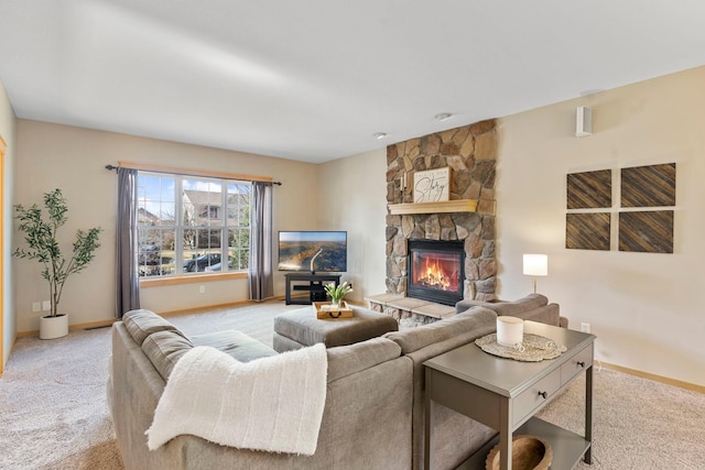 carpeted living area with baseboards and a stone fireplace