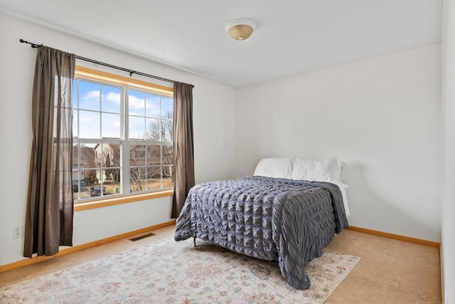 carpeted bedroom with visible vents and baseboards