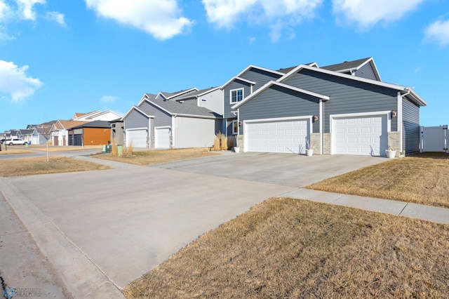 view of front of home featuring a front lawn, an attached garage, a residential view, and driveway