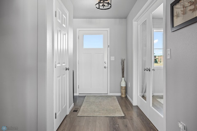 entrance foyer featuring dark wood finished floors, visible vents, and baseboards