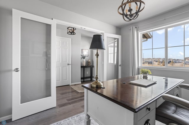 office featuring baseboards, an inviting chandelier, and wood finished floors