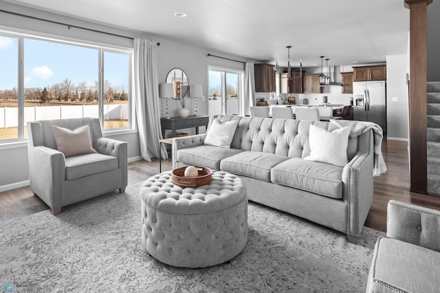 living room featuring baseboards, stairs, and light wood finished floors