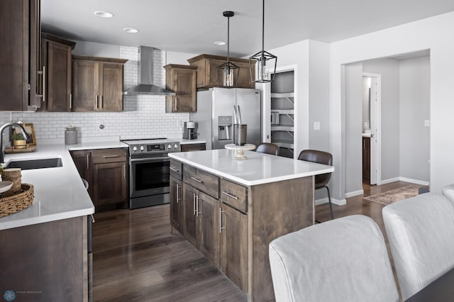 kitchen with tasteful backsplash, appliances with stainless steel finishes, dark wood-style floors, wall chimney exhaust hood, and a sink