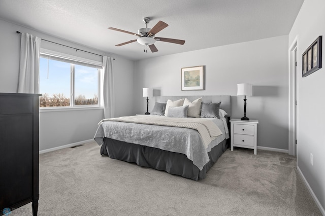 bedroom featuring visible vents, a ceiling fan, a textured ceiling, carpet floors, and baseboards