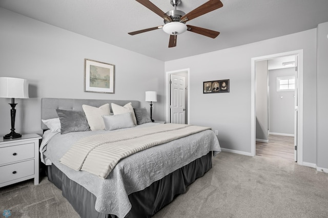 bedroom featuring light colored carpet, a ceiling fan, and baseboards