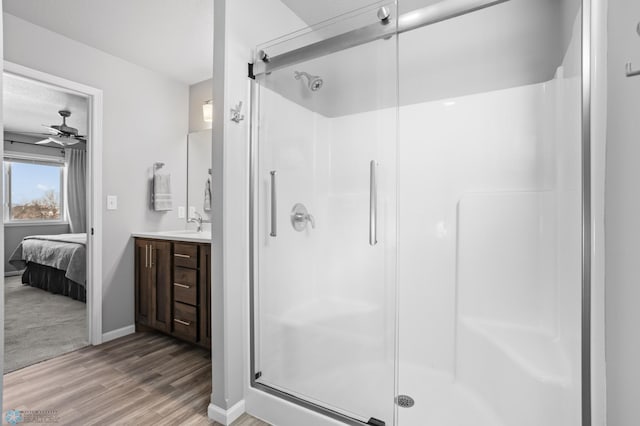 ensuite bathroom featuring ensuite bathroom, wood finished floors, and a shower stall