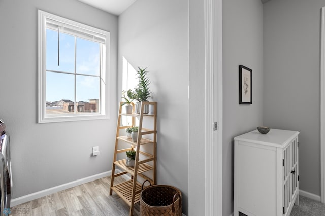 washroom with laundry area, light wood-style flooring, and baseboards